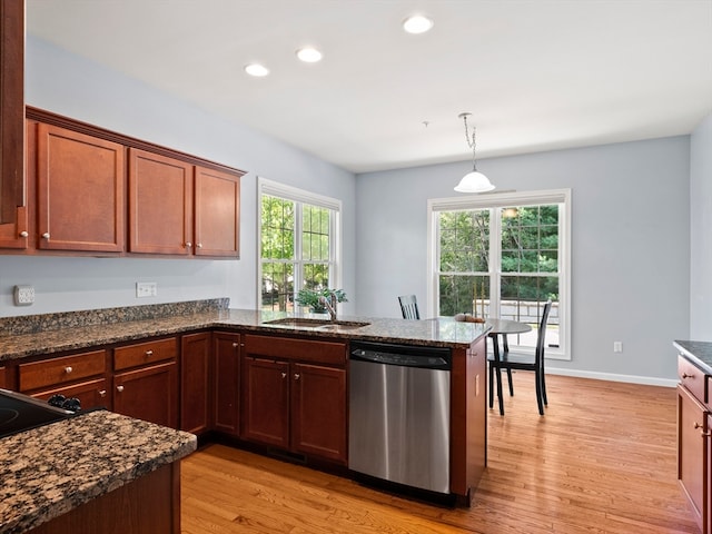 kitchen featuring hanging light fixtures, stainless steel dishwasher, kitchen peninsula, and light wood-type flooring