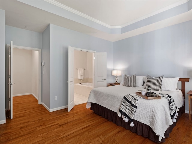 bedroom with wood-type flooring, connected bathroom, and ornamental molding