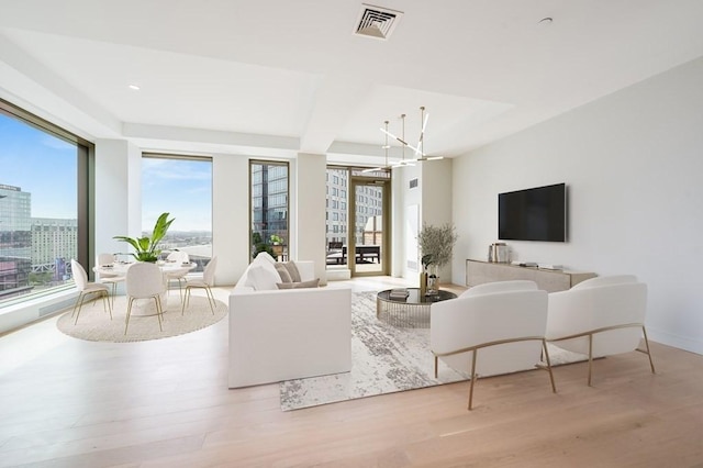 living room featuring a chandelier and light hardwood / wood-style flooring