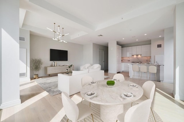 dining area featuring a notable chandelier and light hardwood / wood-style floors