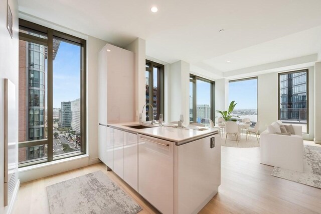 kitchen with white cabinets, sink, and a wealth of natural light