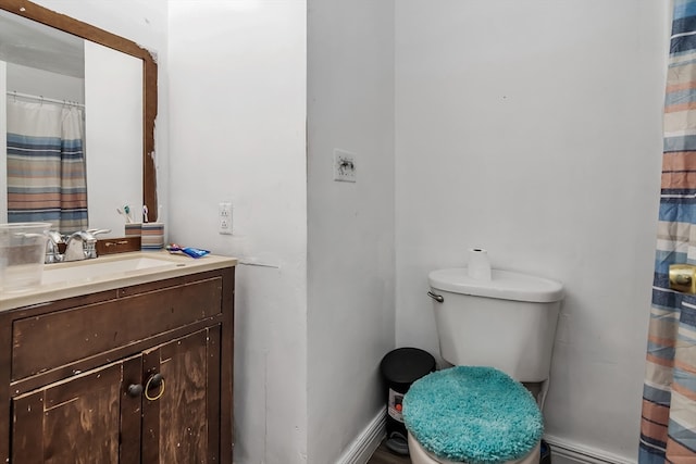 bathroom with vanity, toilet, and a baseboard radiator