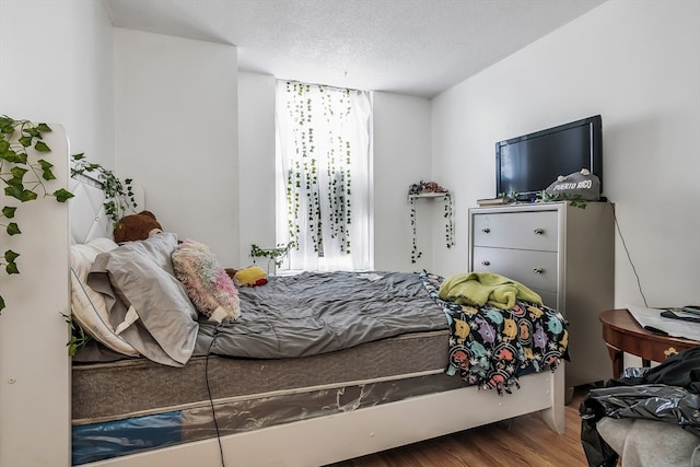 bedroom featuring wood-type flooring and a textured ceiling