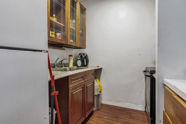 kitchen with dark hardwood / wood-style flooring, white refrigerator, black / electric stove, and sink