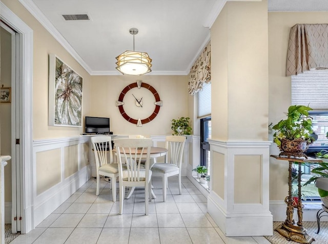 tiled dining area featuring crown molding