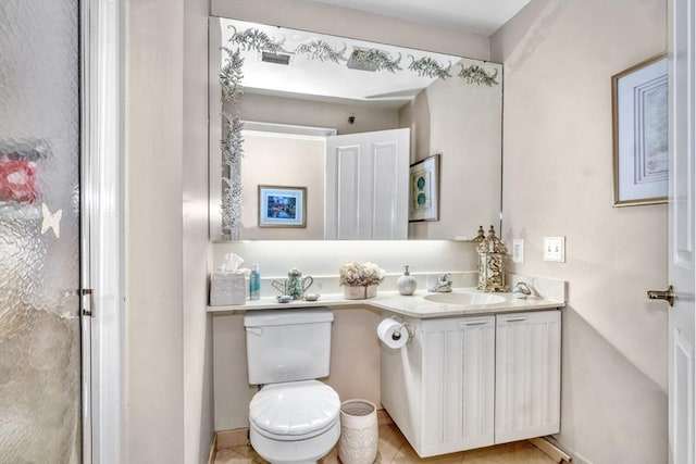 bathroom with tile patterned flooring, vanity, and toilet