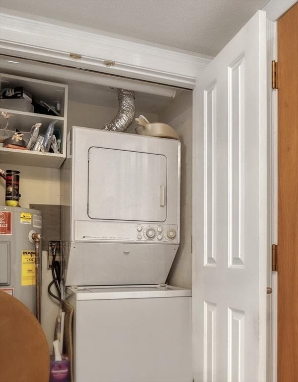 laundry room featuring electric water heater and stacked washing maching and dryer