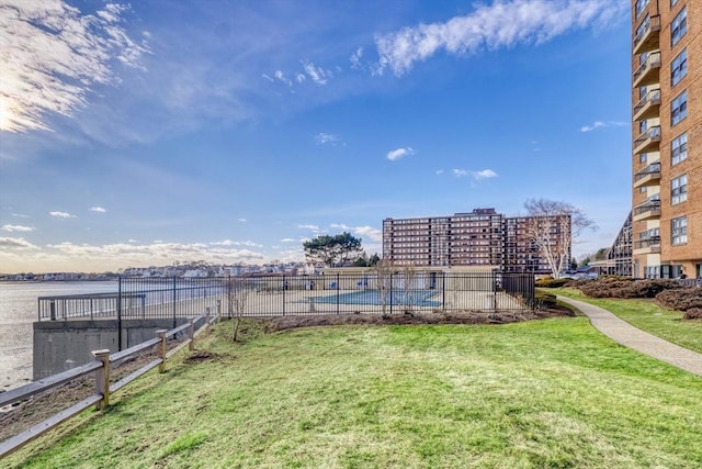 surrounding community featuring a lawn, a swimming pool, and a water view