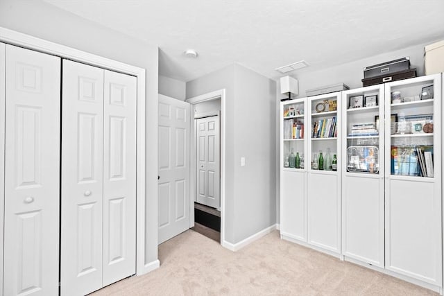 unfurnished bedroom featuring light colored carpet and a closet