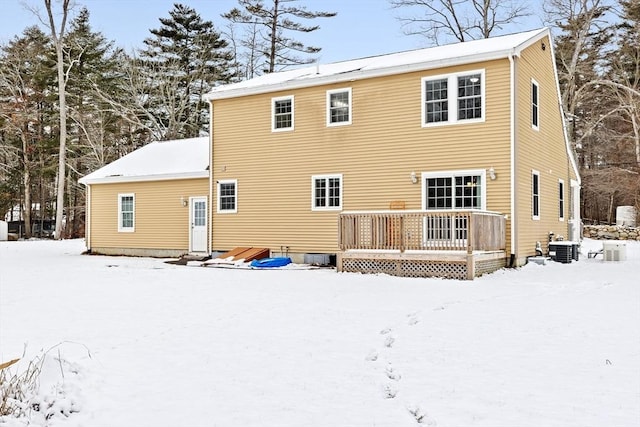 snow covered back of property featuring a wooden deck and central air condition unit