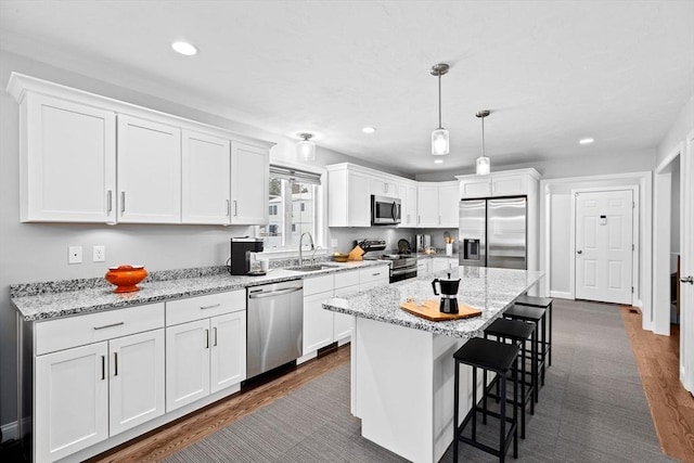 kitchen with white cabinetry, pendant lighting, stainless steel appliances, and a center island