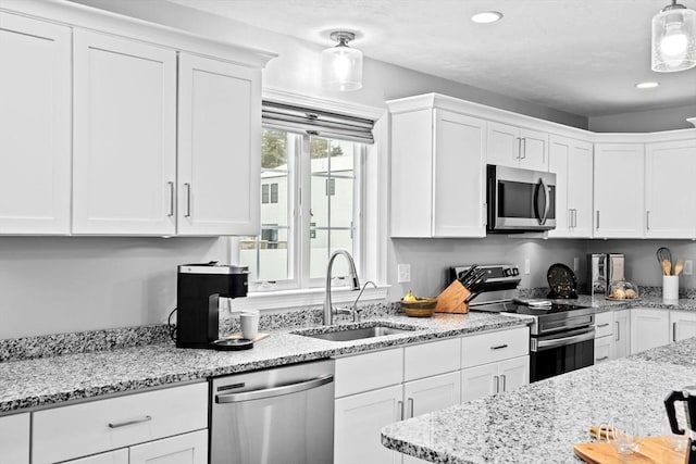 kitchen with stainless steel appliances, white cabinetry, and sink