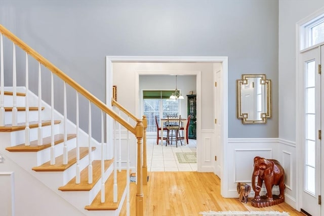 31 Fox Holw, Plymouth, MA 02360 - foyer featuring light wood-style flooring, stairway, a wainscoted wall, and a decorative wall
