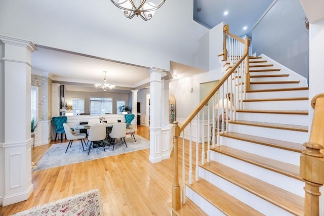 31 Fox Holw, Plymouth, MA 02360 - stairs with a chandelier, ornate columns, wood finished floors, crown molding, and a decorative wall