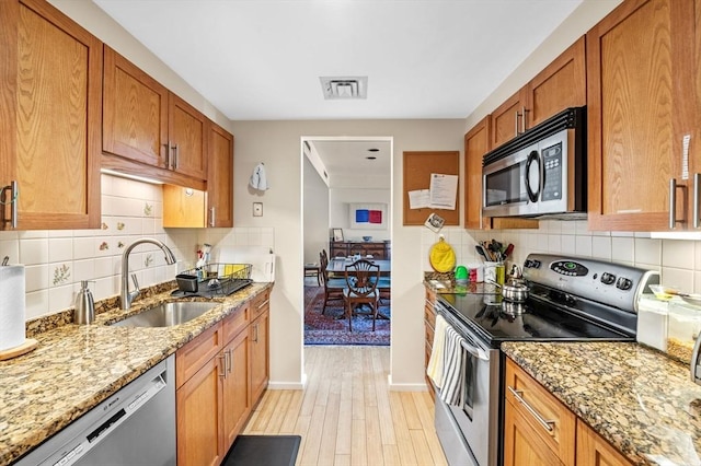 130 Mount Auburn St Unit 204, Cambridge, MA 02138 - kitchen featuring appliances with stainless steel finishes, light wood finished floors, and light stone countertops