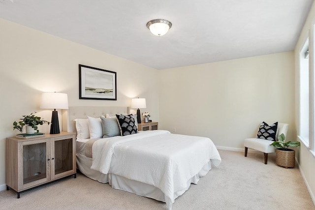 bedroom with light carpet and baseboards