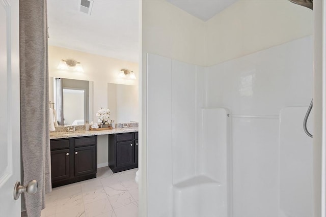 bathroom with marble finish floor, walk in shower, vanity, and visible vents
