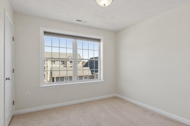 carpeted empty room featuring visible vents and baseboards
