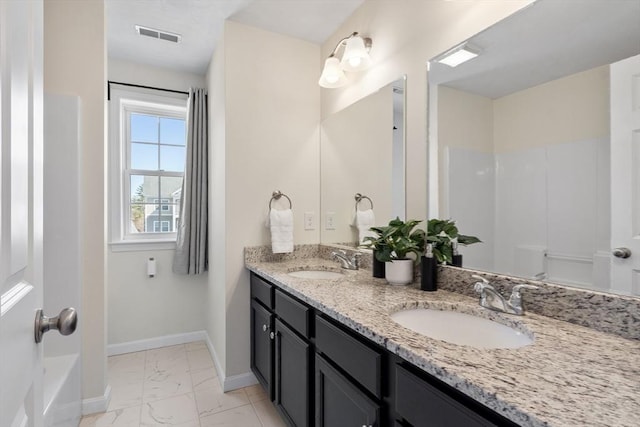 bathroom with visible vents, marble finish floor, baseboards, and a sink