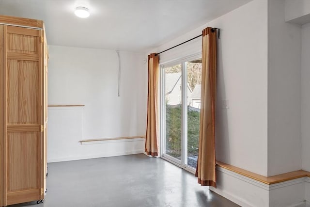 spare room with finished concrete flooring and baseboards