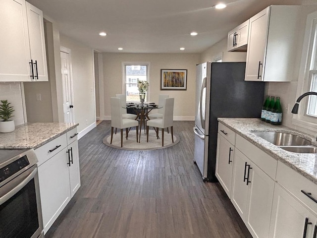 kitchen featuring light stone counters, sink, white cabinets, and stainless steel appliances