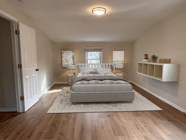 bedroom with hardwood / wood-style flooring and lofted ceiling