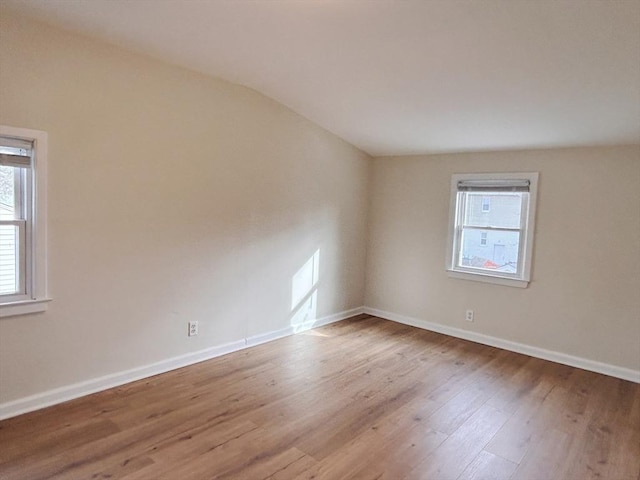 spare room featuring hardwood / wood-style floors and lofted ceiling