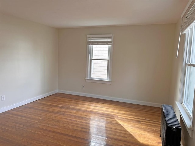 unfurnished room featuring hardwood / wood-style flooring and radiator