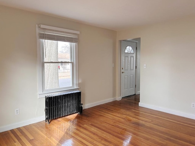 foyer entrance with radiator and hardwood / wood-style floors