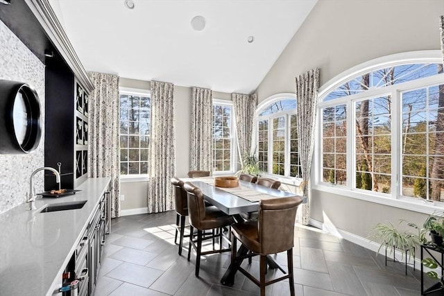 sunroom / solarium with vaulted ceiling and a sink