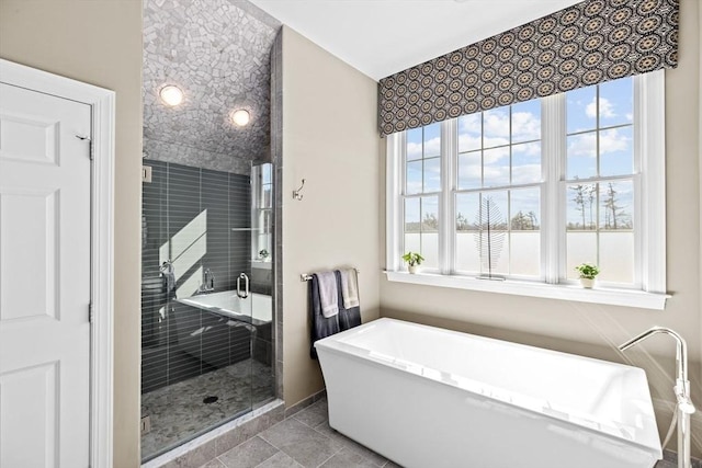 bathroom featuring tile patterned flooring, a soaking tub, and a shower stall