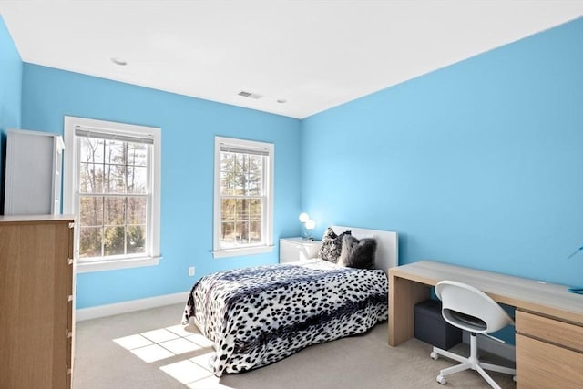 carpeted bedroom featuring visible vents, multiple windows, and baseboards