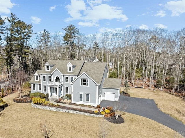 view of front of home featuring a front lawn, a balcony, and driveway