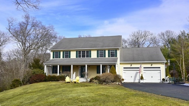 view of front of home featuring an attached garage, a front yard, a porch, and driveway