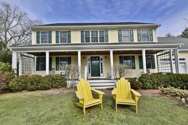 colonial inspired home featuring a front yard and covered porch