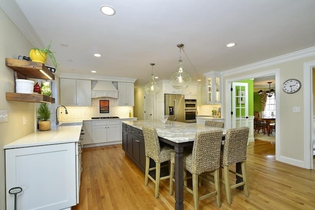 kitchen with open shelves, custom exhaust hood, stainless steel appliances, white cabinetry, and crown molding