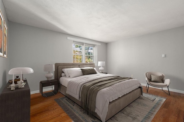 bedroom featuring baseboards, a textured ceiling, and wood finished floors
