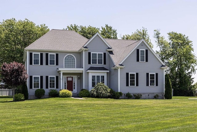 view of front of property featuring a front yard and a shingled roof