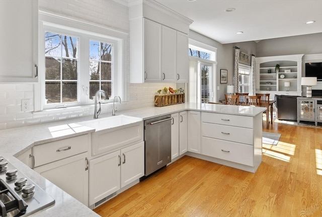 kitchen featuring a sink, light wood-style floors, appliances with stainless steel finishes, and white cabinets