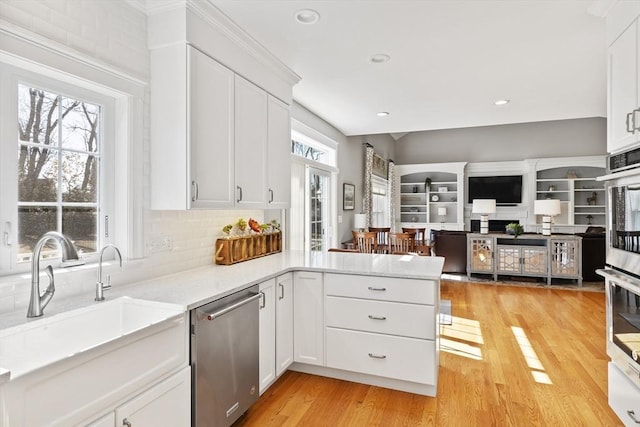 kitchen with a wealth of natural light, stainless steel appliances, light wood-style floors, and a sink