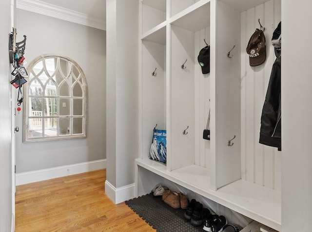 mudroom with crown molding, light wood-style flooring, and baseboards