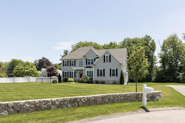 colonial inspired home featuring a front yard and fence