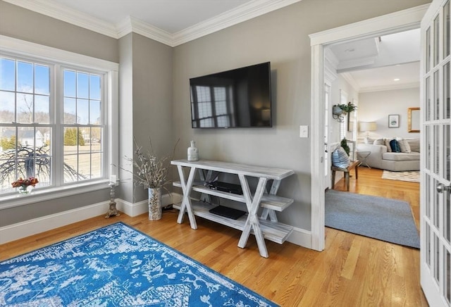 interior space with french doors, baseboards, wood finished floors, and crown molding