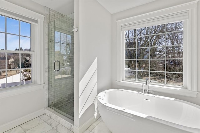 bathroom with baseboards, plenty of natural light, and a shower stall