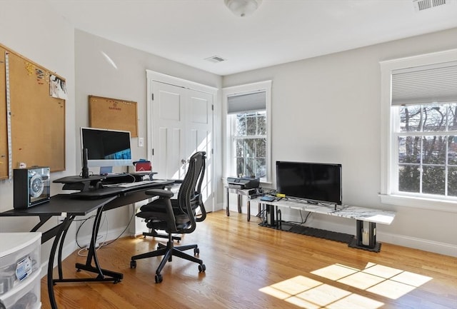 home office featuring visible vents, baseboards, and wood finished floors