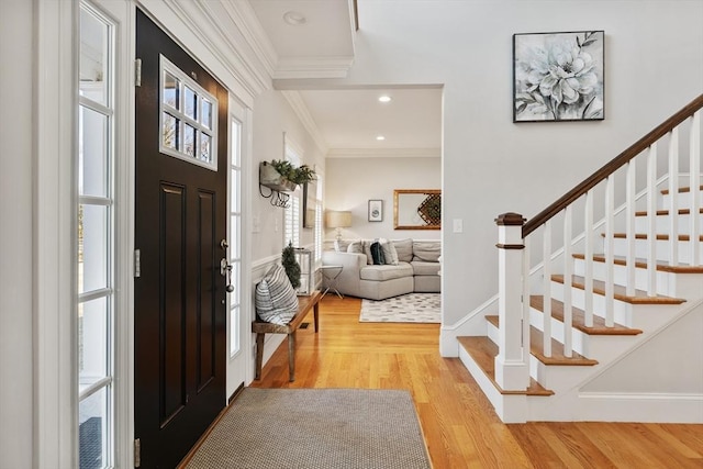 foyer with recessed lighting, stairway, light wood-style floors, crown molding, and baseboards