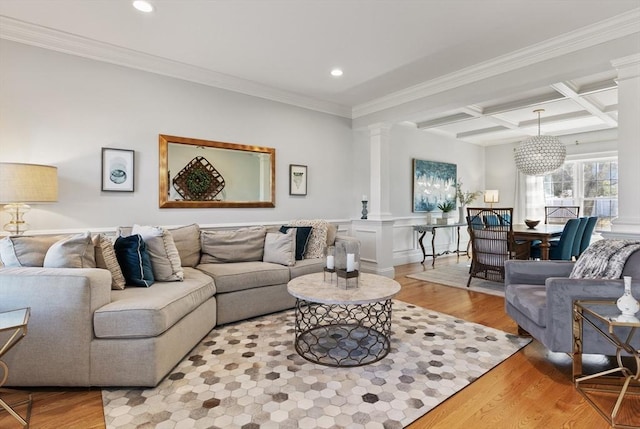 living area featuring beamed ceiling, coffered ceiling, ornate columns, and wood finished floors