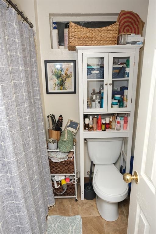218 W 8th St, Boston, MA 02127 - full bath featuring toilet, tile patterned floors, and a shower with shower curtain