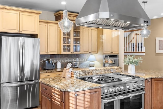 kitchen with pendant lighting, backsplash, light stone countertops, appliances with stainless steel finishes, and island range hood