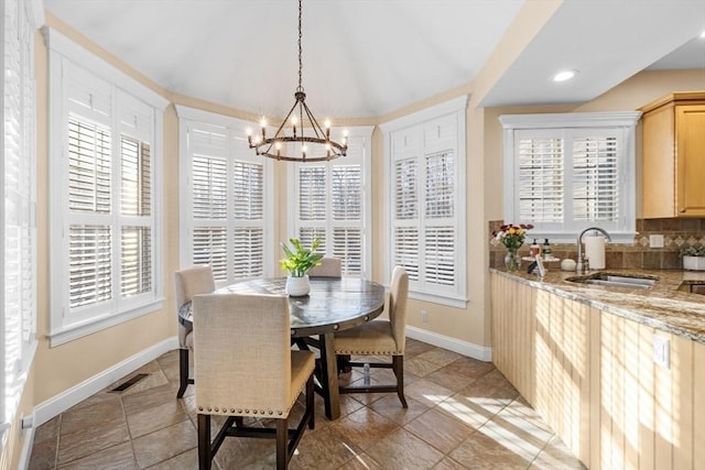 tiled dining room with a chandelier and sink